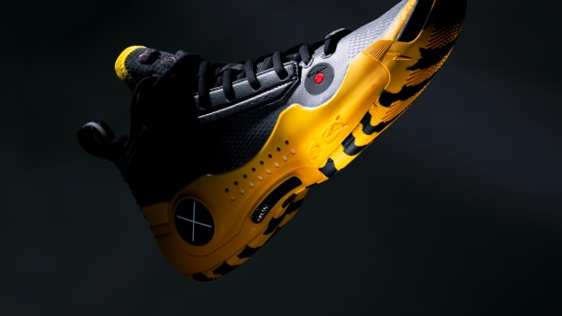 Side view of black and yellow Way of Wade basketball sneakers.